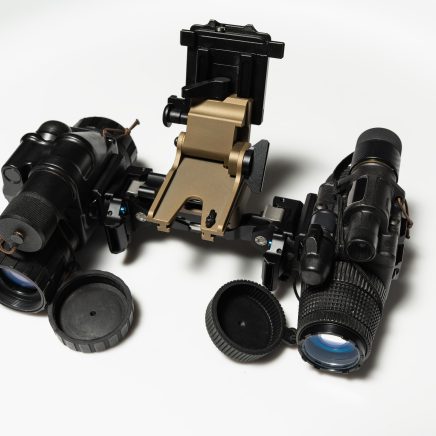 Modern tactical night vision binoculars assembled from two high-performance monocular modules on a white background for various tasks.